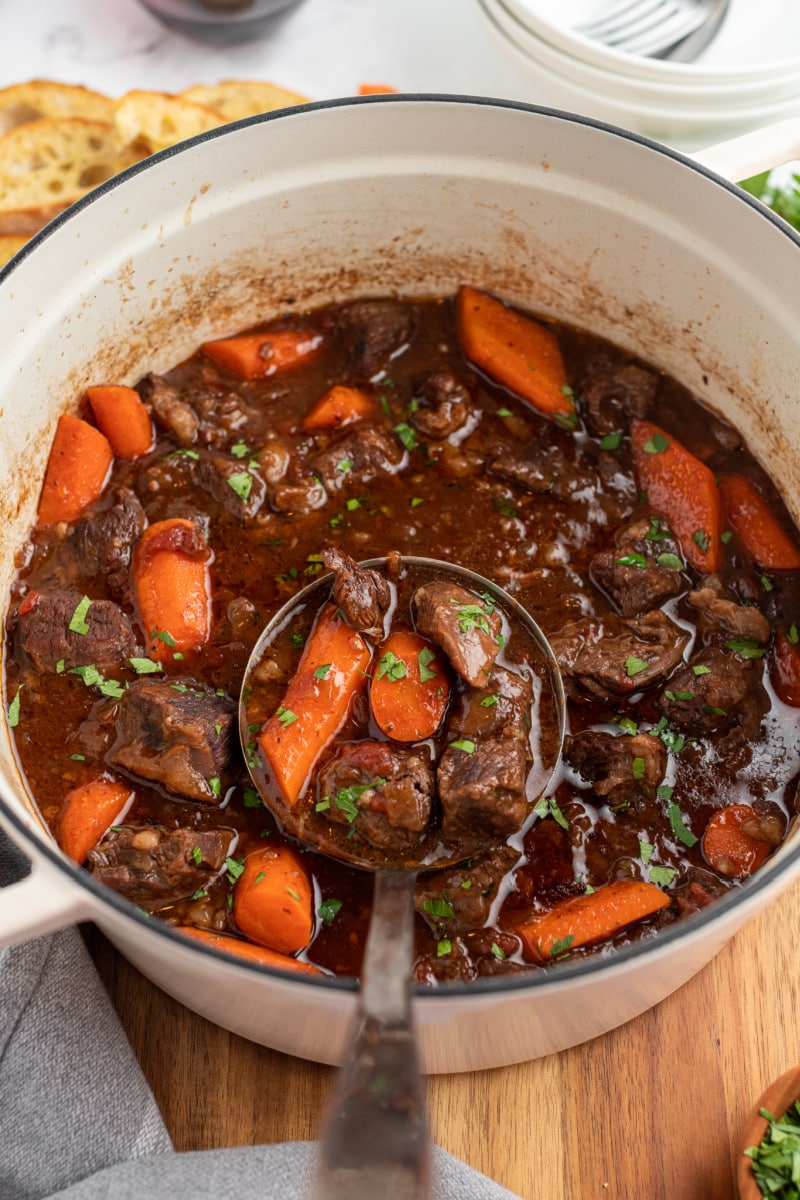 ladling out beef stew from pot