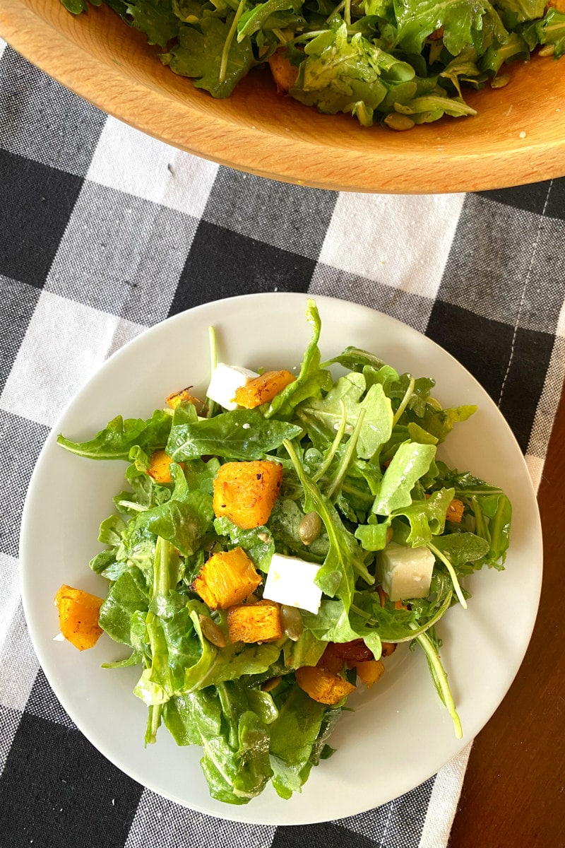 serving of maple roasted pumpkin salad on white plate