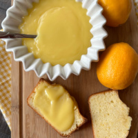 meyer lemon curd in bowl and slices of bread with lemon curd spread on