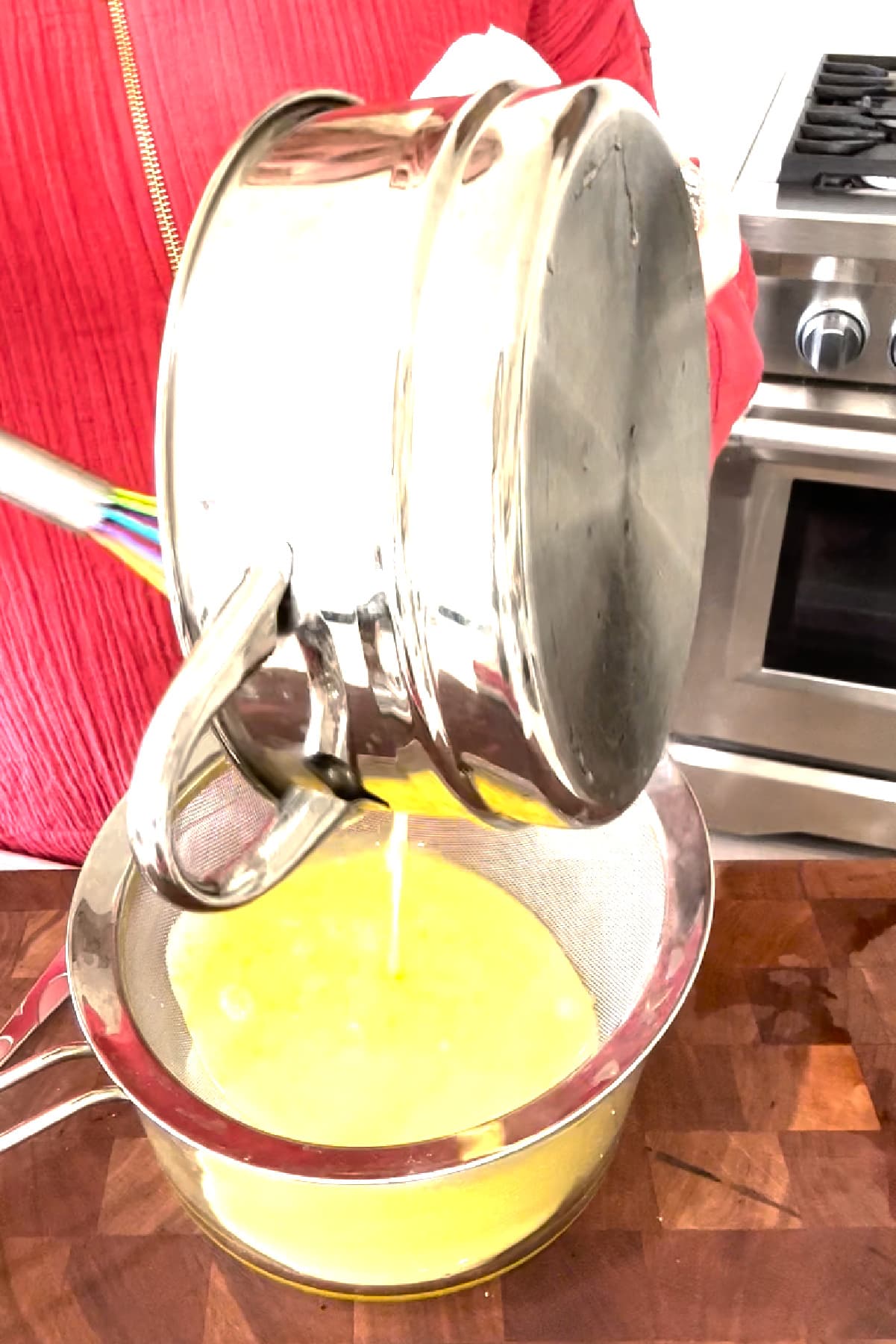 pouring lemon curd into fine mesh strainer