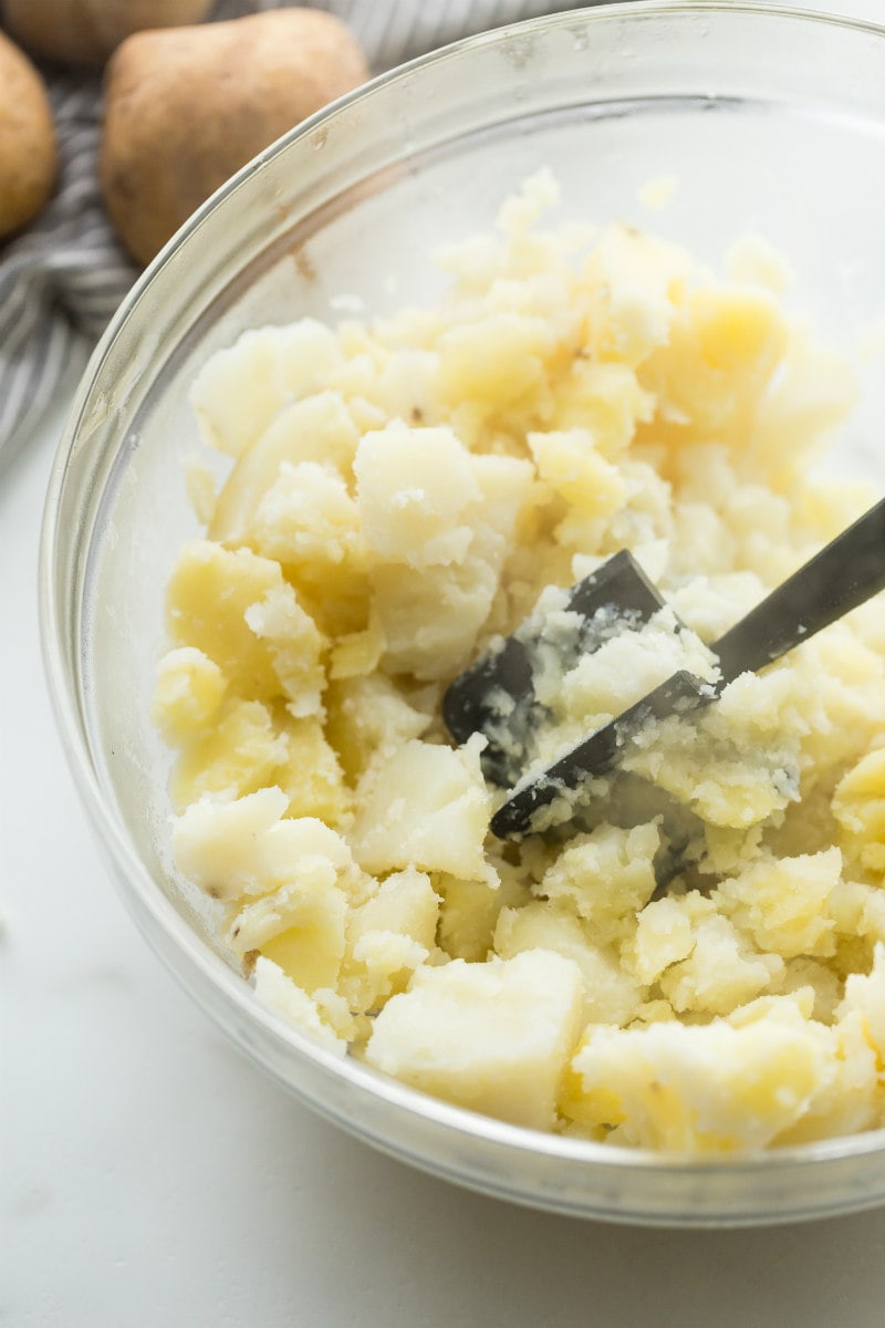 Mashing potatoes in a bowl