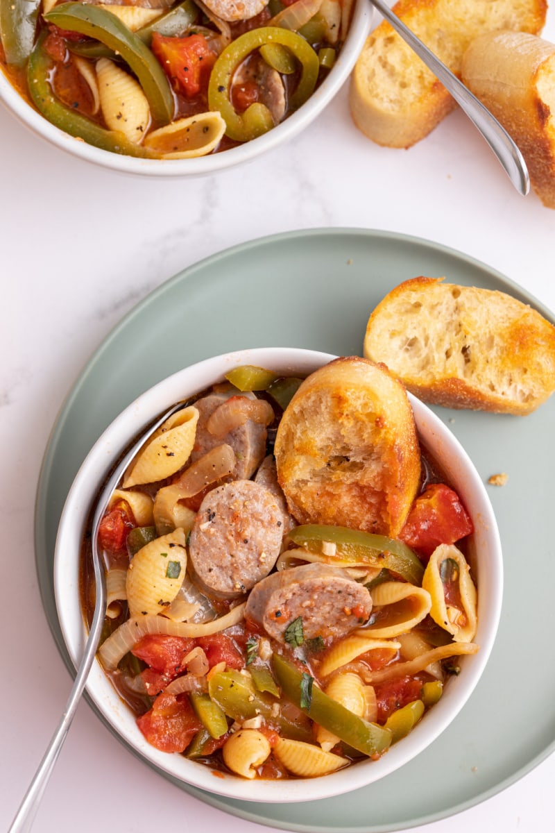 bowl of sausage and pepper stew with slices of toasted bread