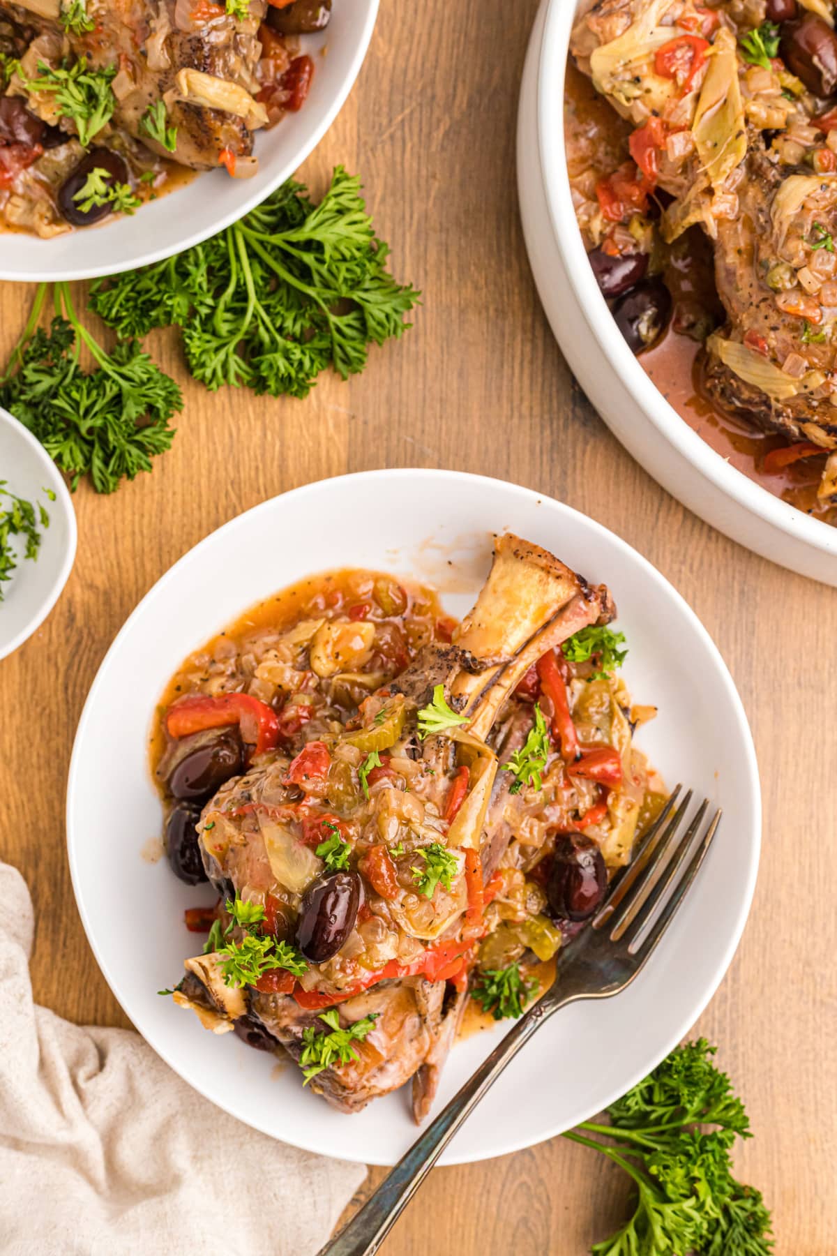 plate of lamb shank topped with artichoke caponata