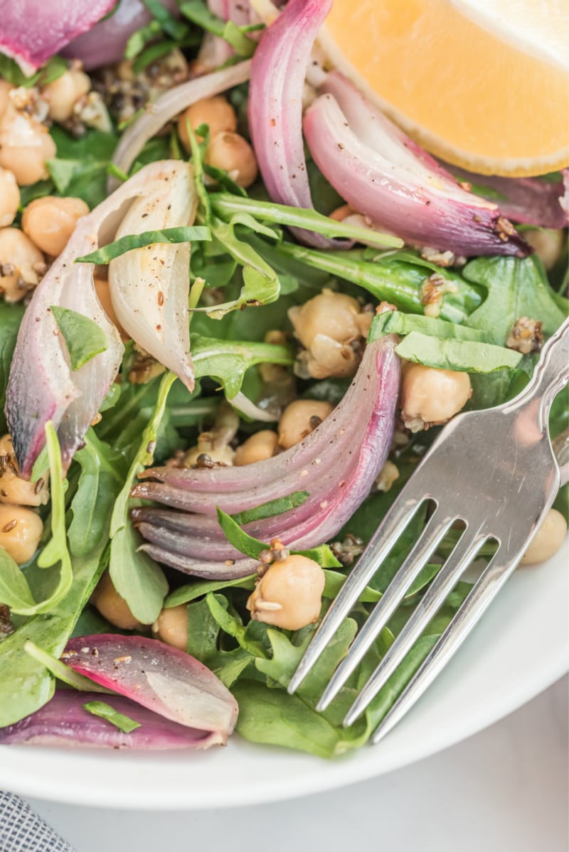 peek at a bowl of spinach and arugula salad with indian spiced chickpeas