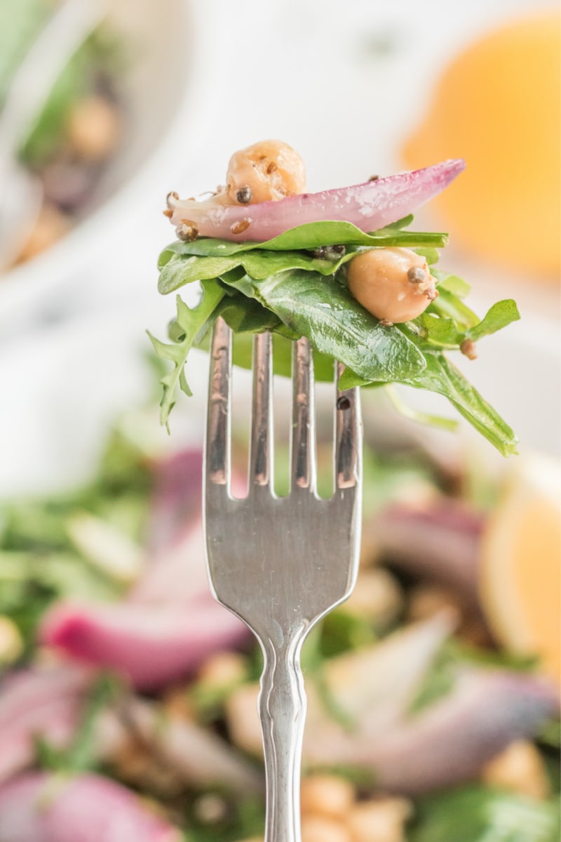 forkful of spinach and arugula salad with indian spiced chickpeas