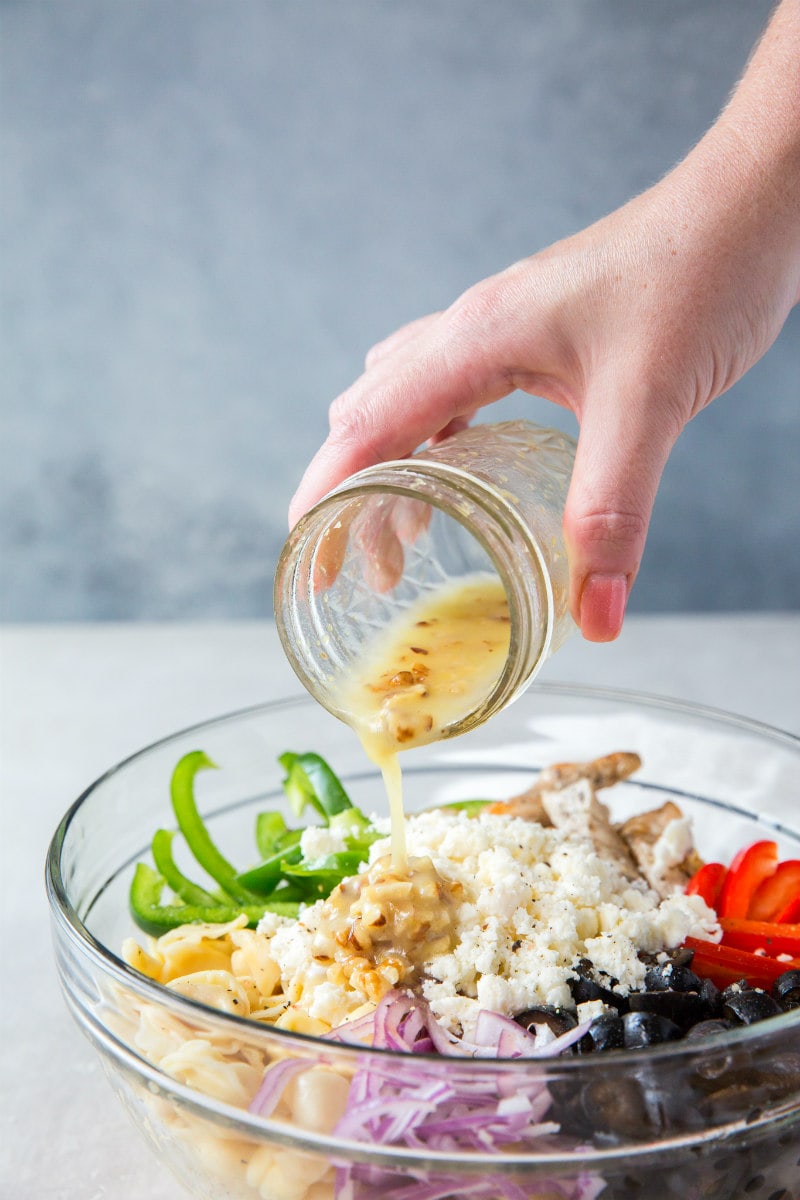 Adding dressing to Greek Tortellini Salad