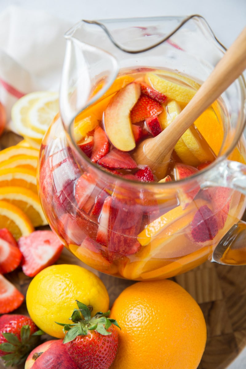 pitcher of strawberry peach sangria surrounded by fresh fruit