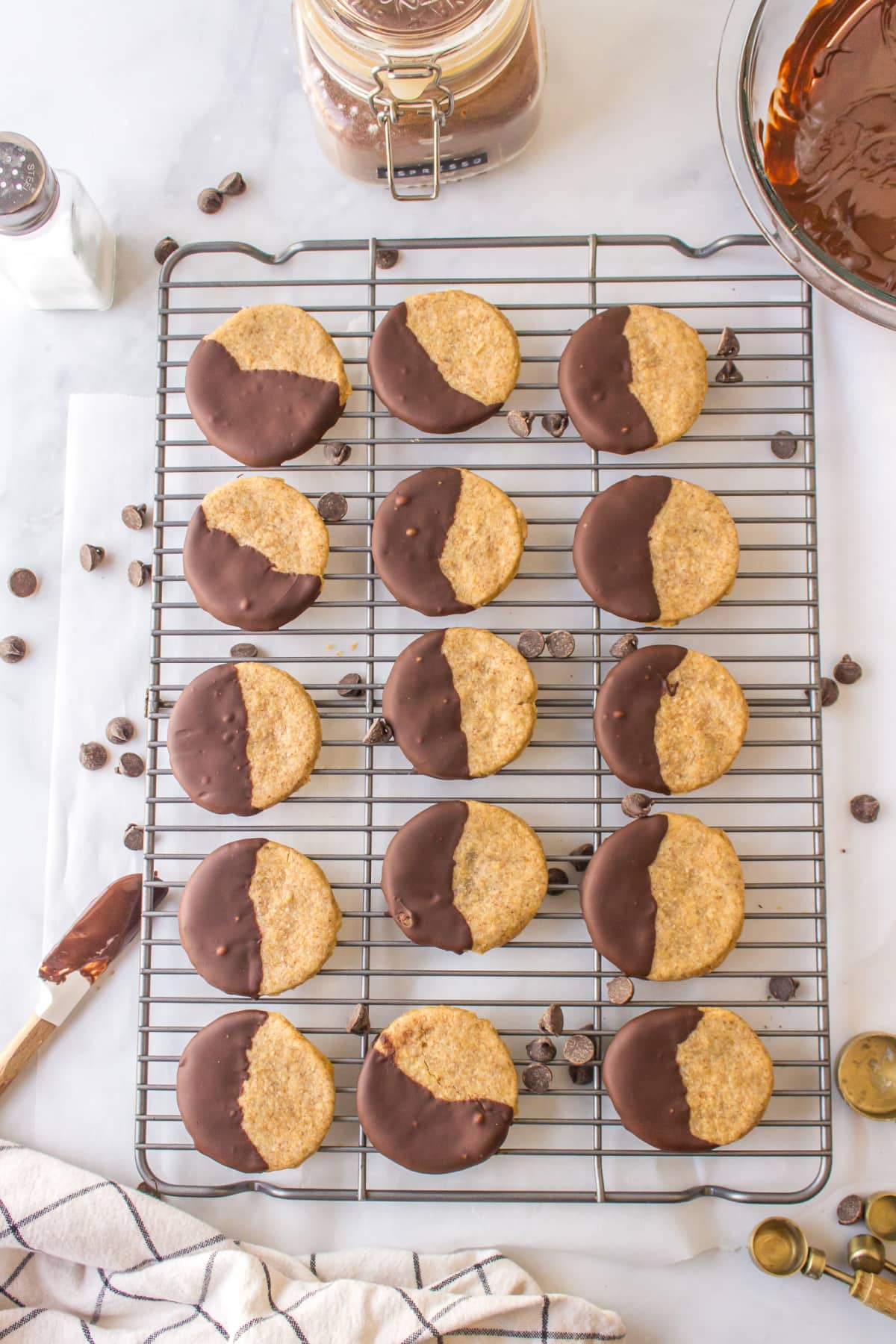 cookies half dipped in chocolate on a cooling rack