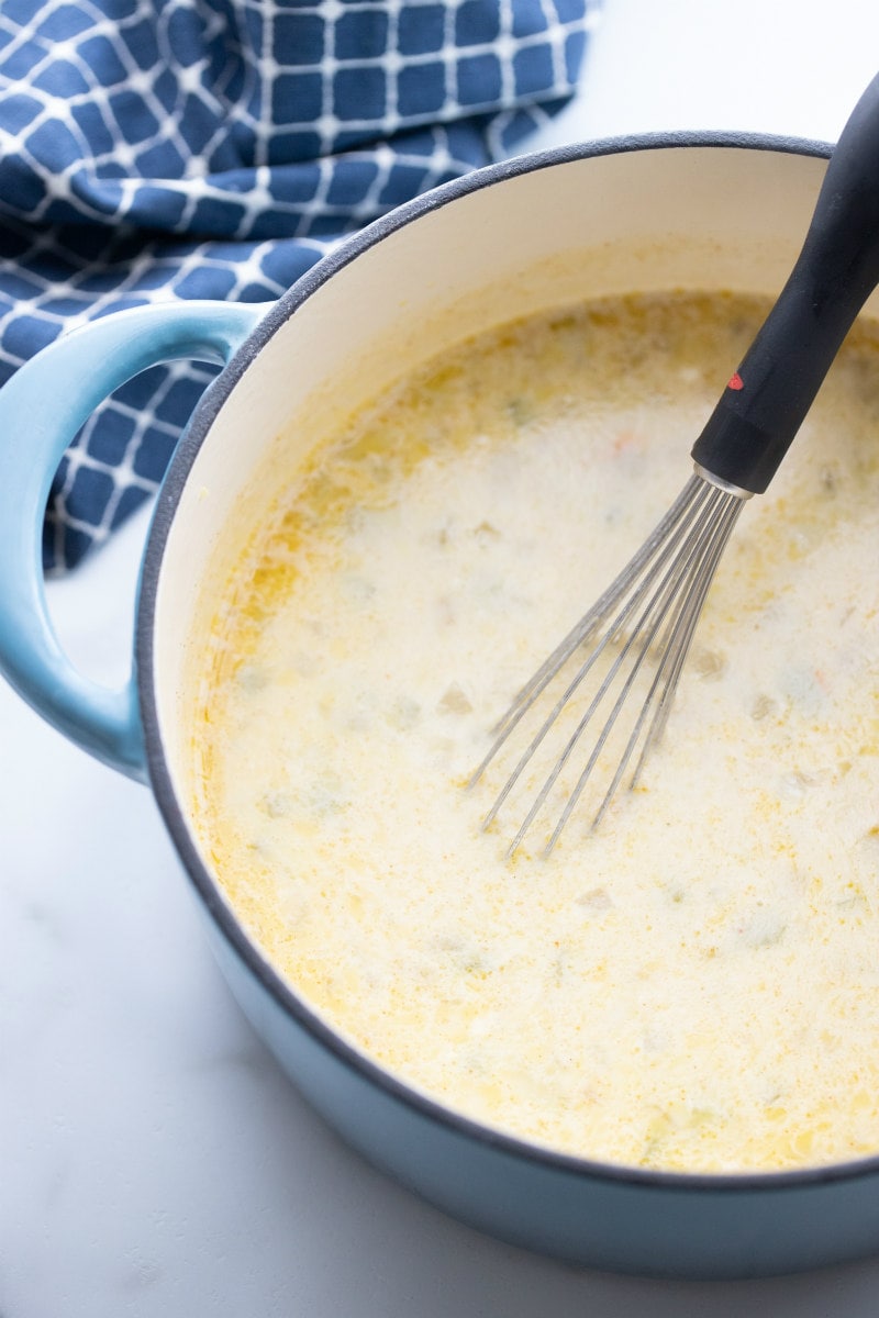 whisking mexican turkey soup in pot