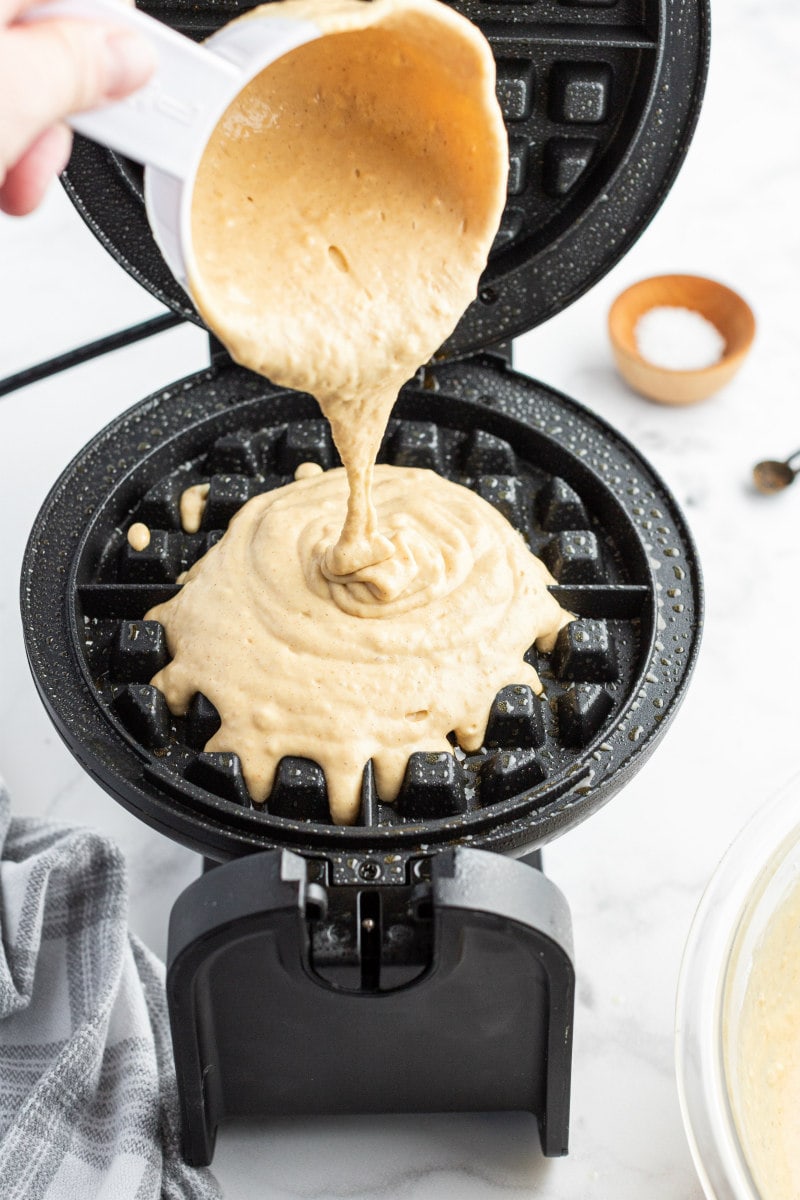 pouring waffle batter into waffle iron