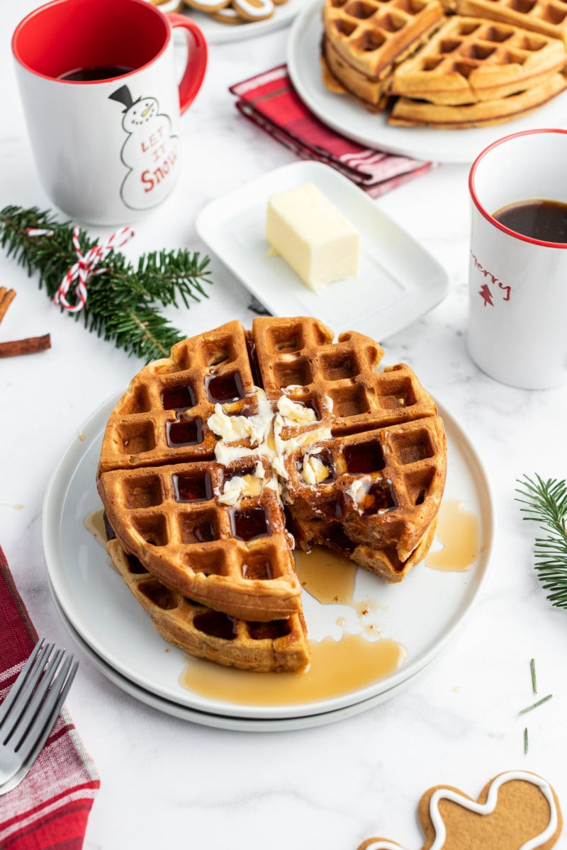 gingerbread waffles on white plate with butter and syrup