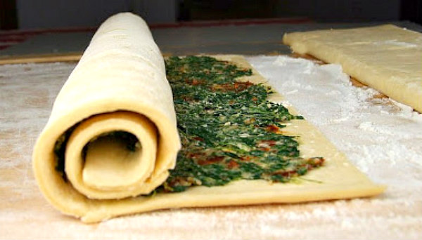 rolling up spinach and sundried tomato in puff pastry