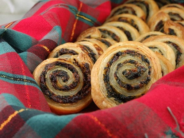 spinach and sundried tomato puff pastries in plaid napkin lined basket