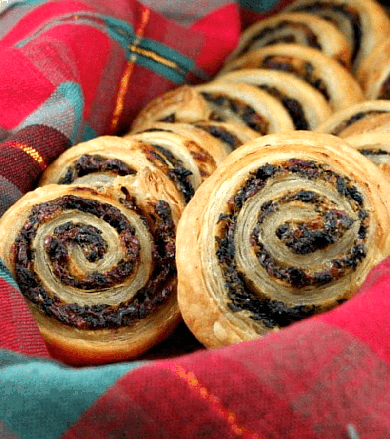 spinach and sundried tomato puff pastries in plaid napkin lined basket