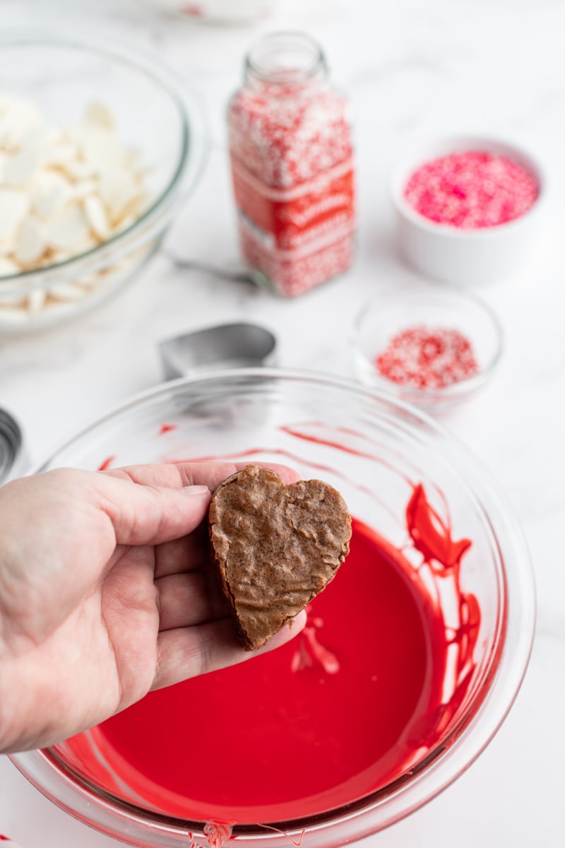 dipping heart shaped brownies in red chocolate