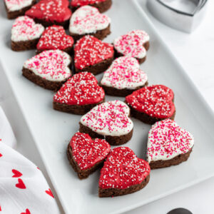 chocolate dipped brownies shaped as hearts on a white platter