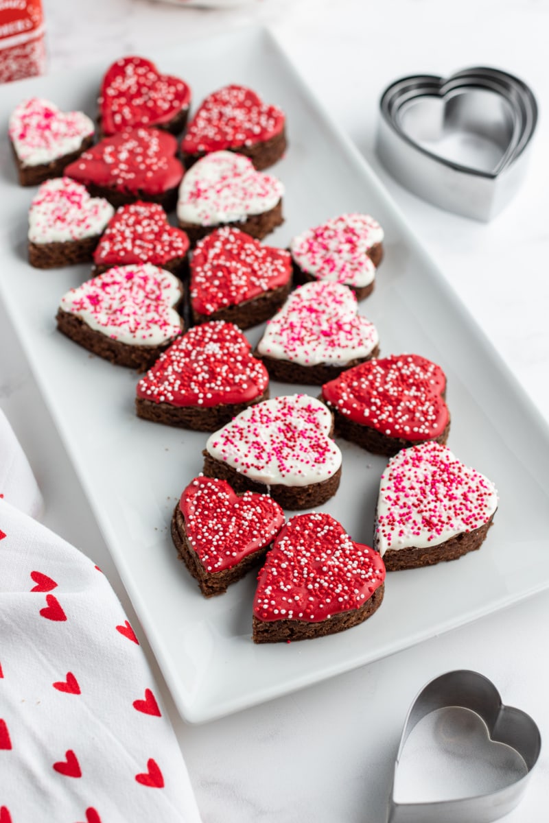chocolate dipped brownies shaped as hearts on a white platter
