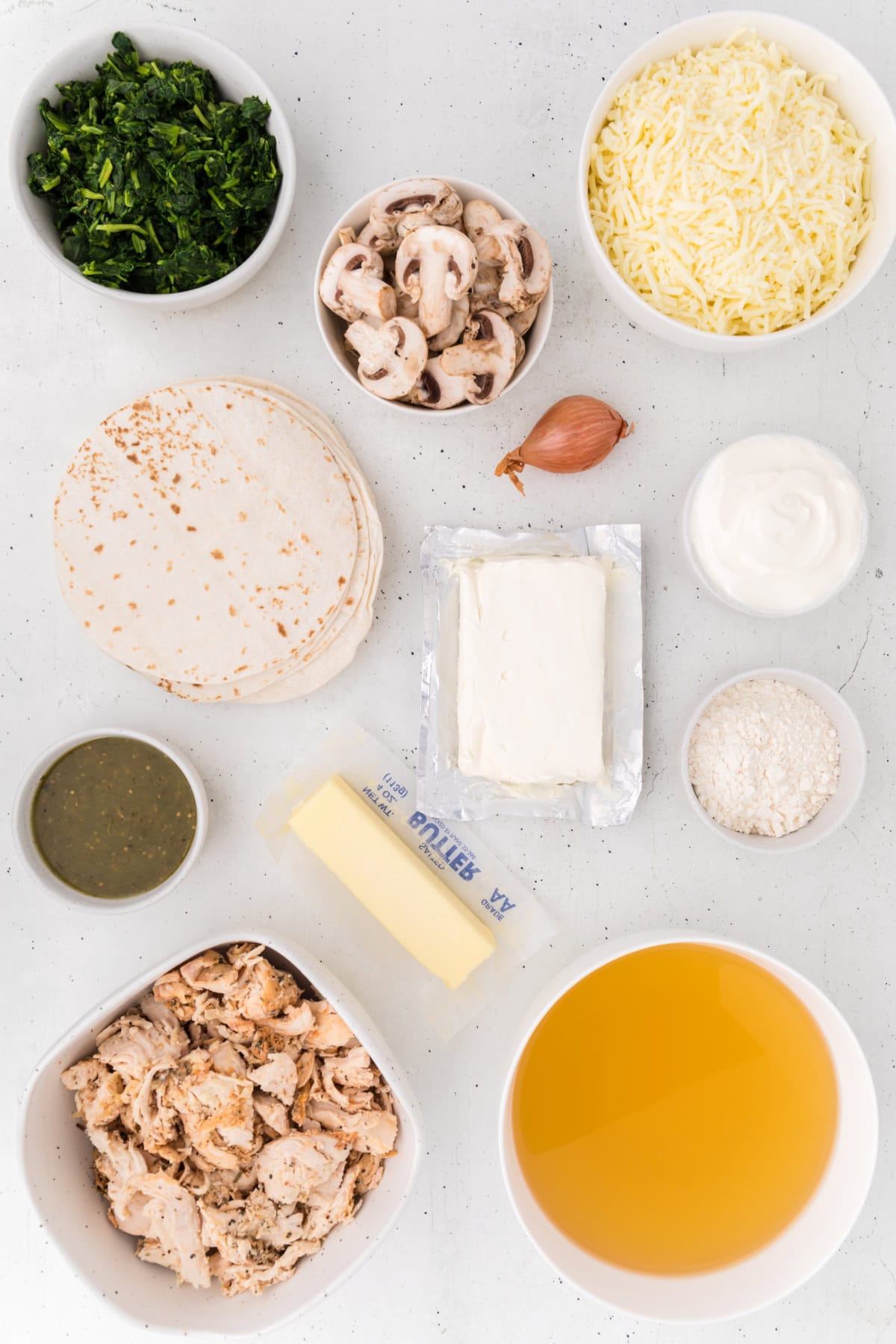 ingredients displayed for making creamy chicken spinach and mushroom enchiladas