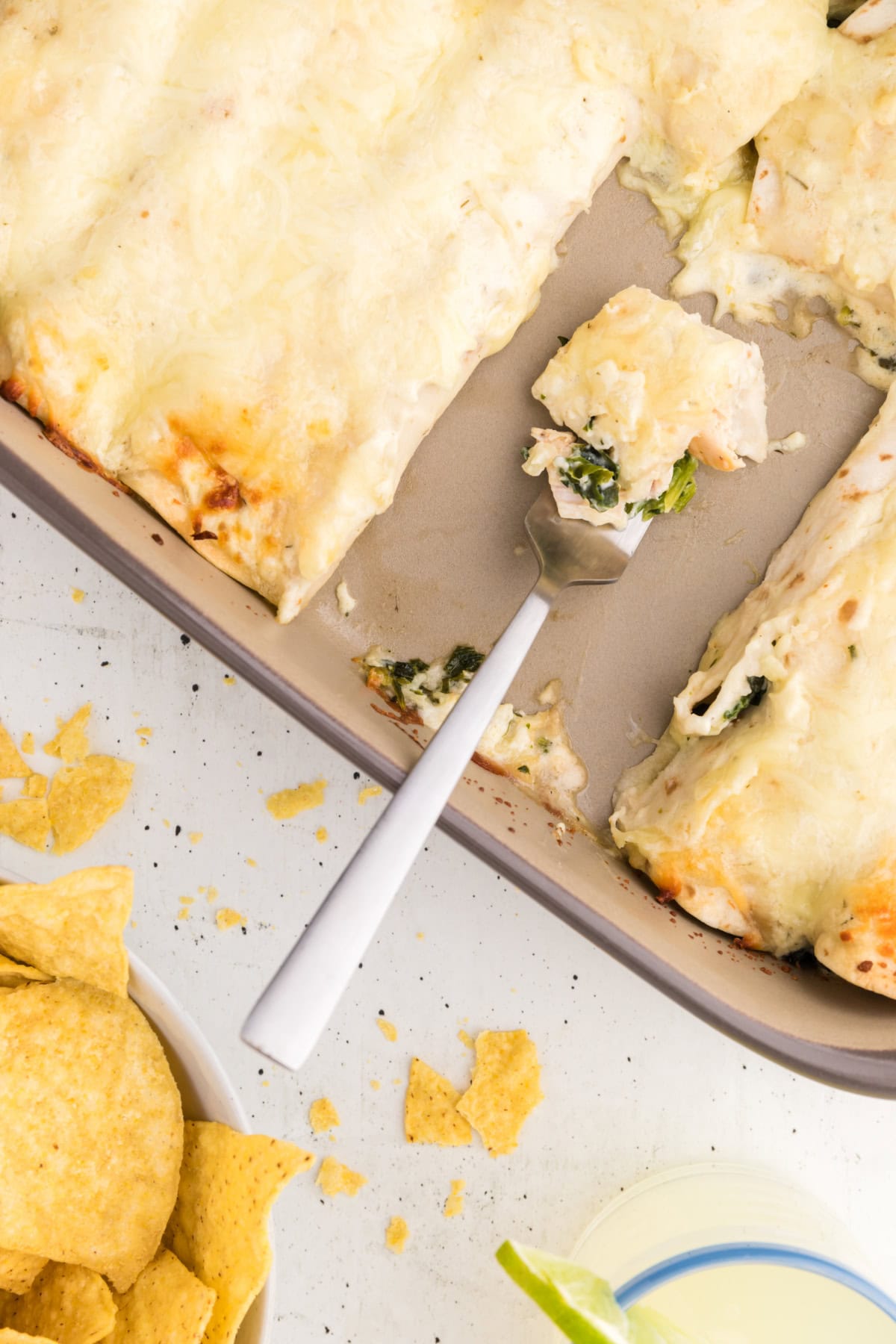 fork full of enchilada in pan of enchiladas