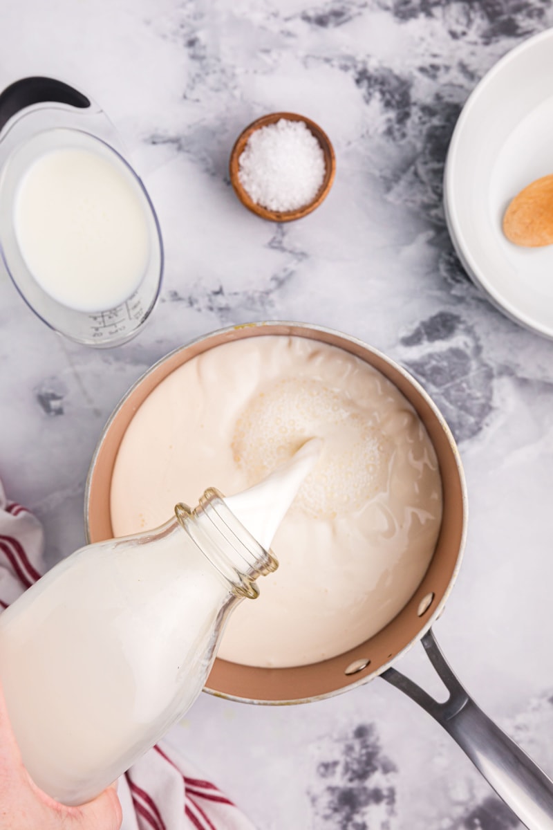 pouring milk into a pan 