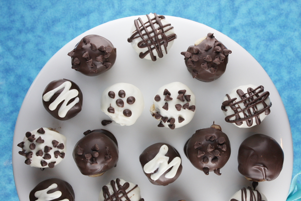 Chocolate Chip Cookie Dough Truffles on a round white plate with a blue background