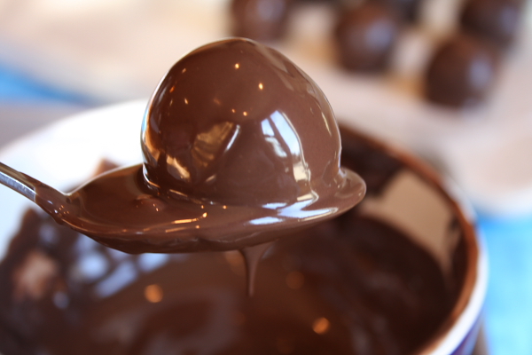 Chocolate Chip Cookie Dough dipped in chocolate with a spoon to make Truffles