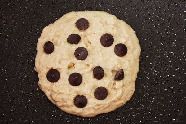 pancake batter in pan with chocolate chips on top