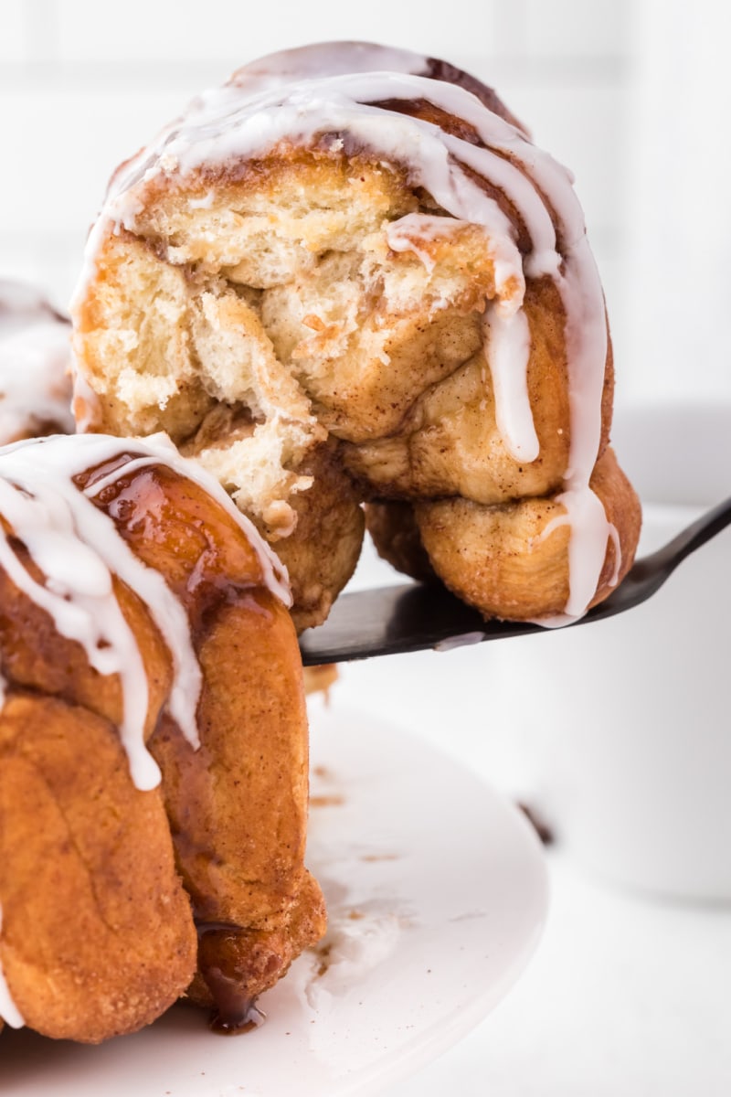 spatula taking piece of monkey bread out of loaf