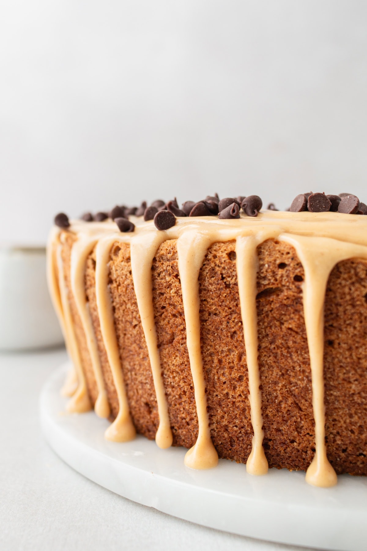 side view of peanut butter pound cake with glaze dripping down the sides