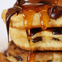 stack of chocolate chip pancakes with syrup dripping off