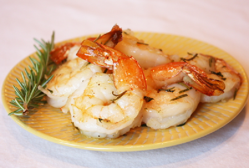 Several pieces of roasted shrimp with rosemary and thyme