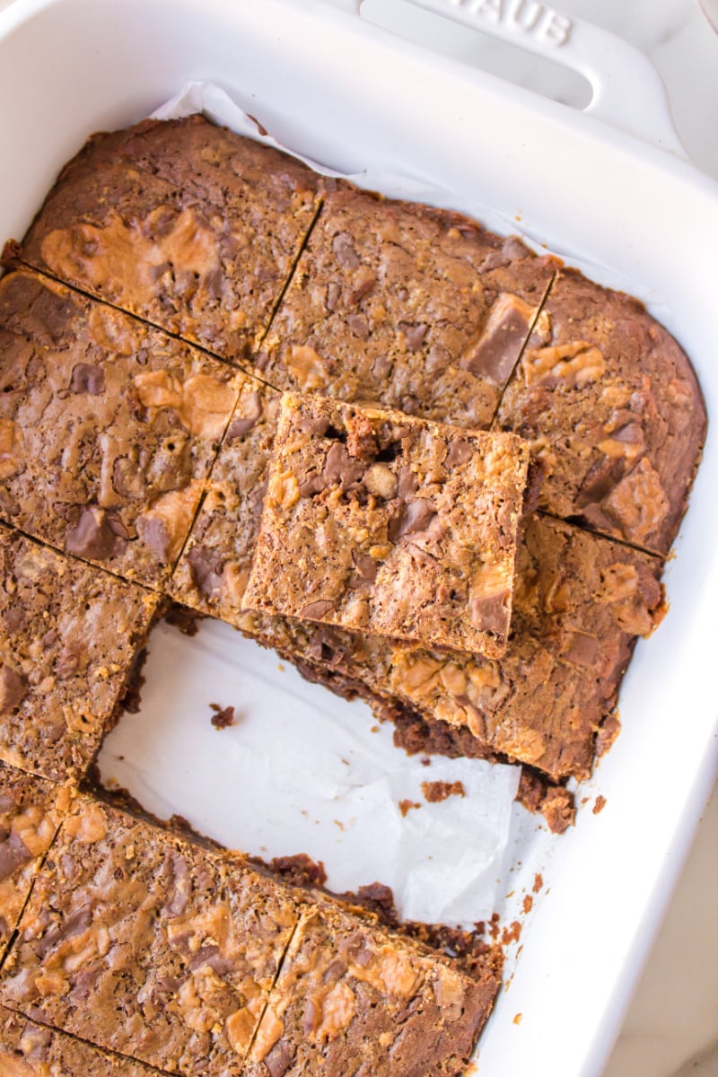 pan of butterfinger brownies with two pieces cut out