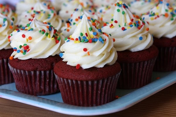 red velvet cupcakes with cream cheese frosting on a white platter