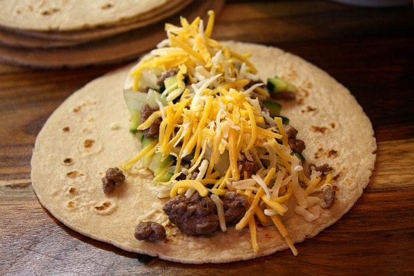 flour tortilla with beef enchilada filling and cheese on top