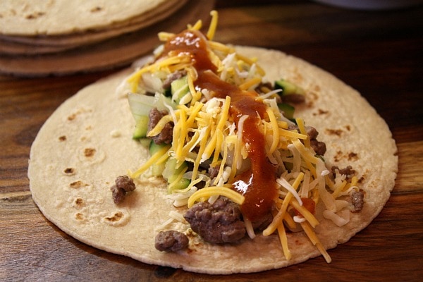 flour tortilla with beef enchilada filling, cheese and hot sauce on top