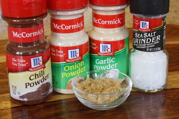 seasonings displayed for pork chop recipe: chili powder onion powder garlic powder salt and brown sugar