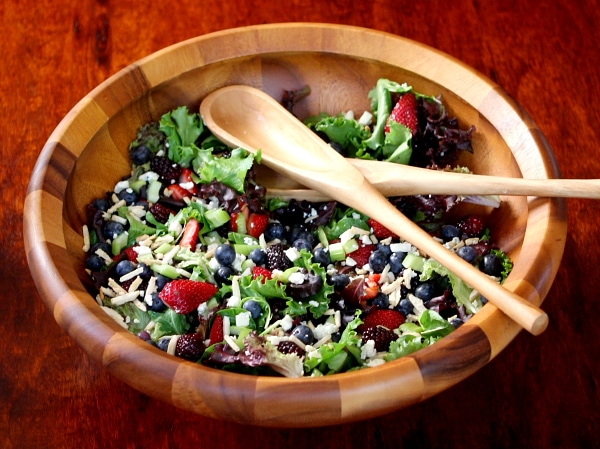 Triple Berry Salad in a large wooden bowl with wooden serving spoons