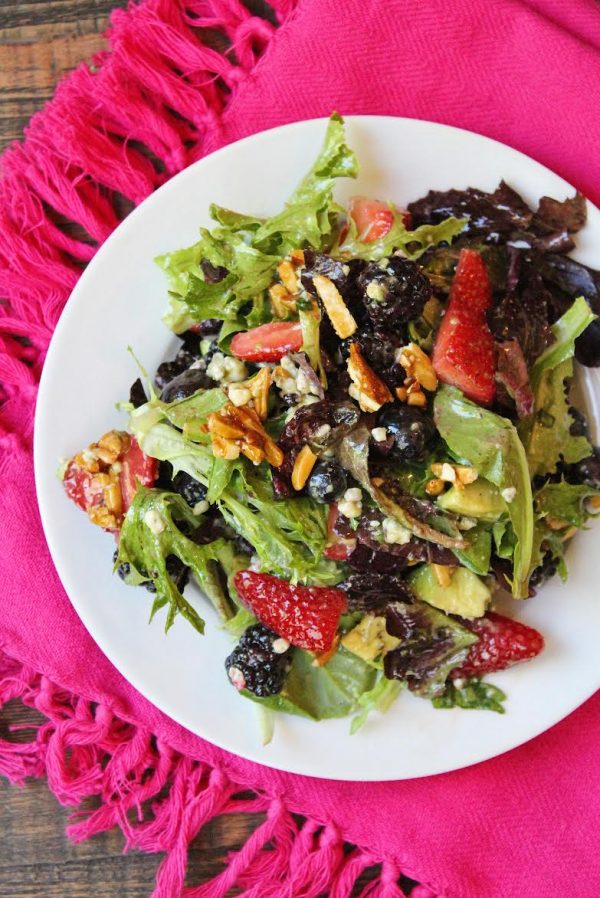 single serving of Triple Berry Salad on a white plate set on a bright pink cloth napkin