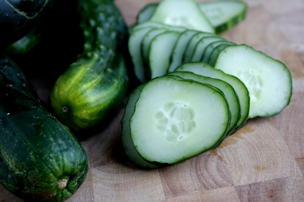 sliced pickling cucumbers sitting on a cutting board