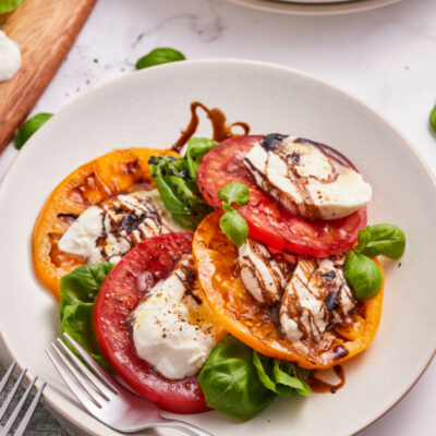 caprese salad with burrata cheese on a white plate