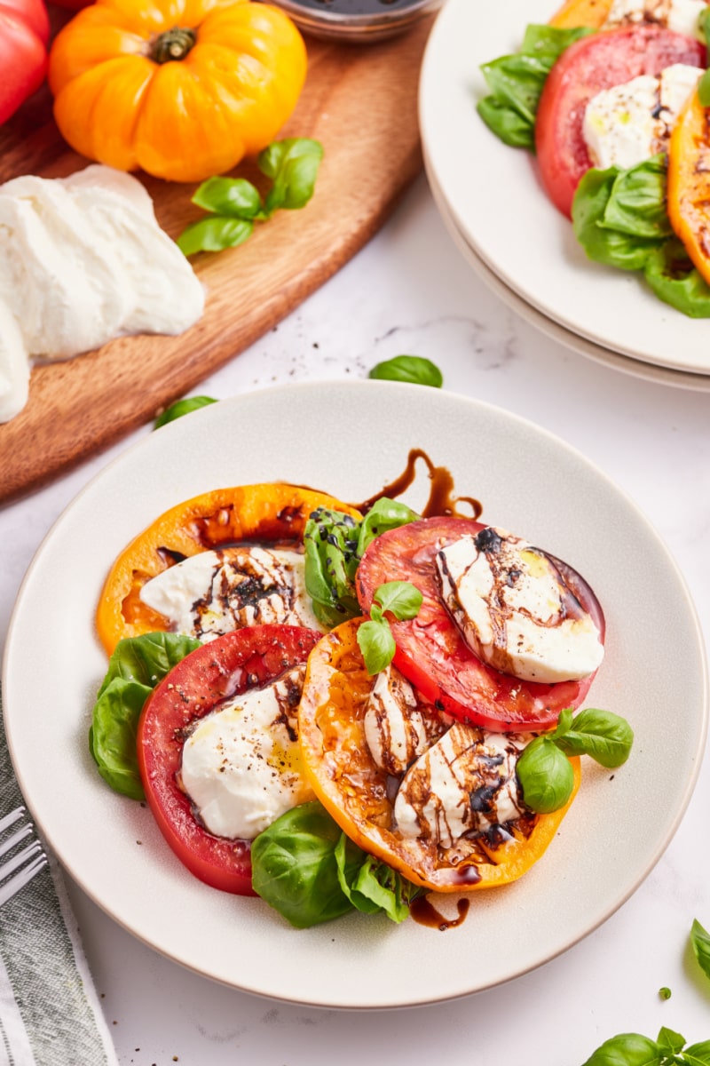 caprese salad with burrata cheese on a white plate