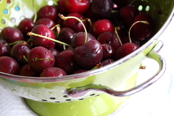 Fresh cherries in a green strainer