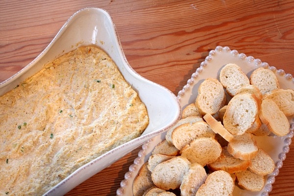 Hot Artichoke and Crab Dip in a dish served with baguette slices