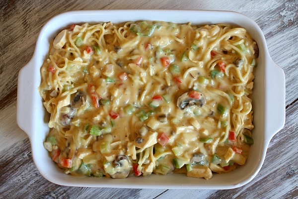 chicken spaghetti casserole in a white casserole dish ready for the oven