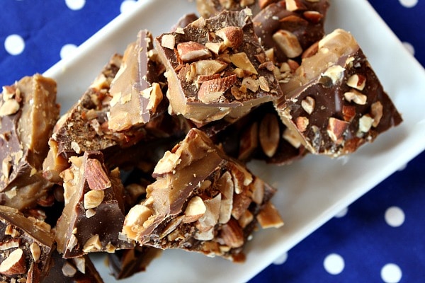 almond roca on a white plate sitting on a blue and white polka dot napkin