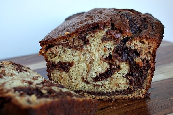 Loaf of Nutella Banana Bread on a cutting board cut to show the inside of the loaf