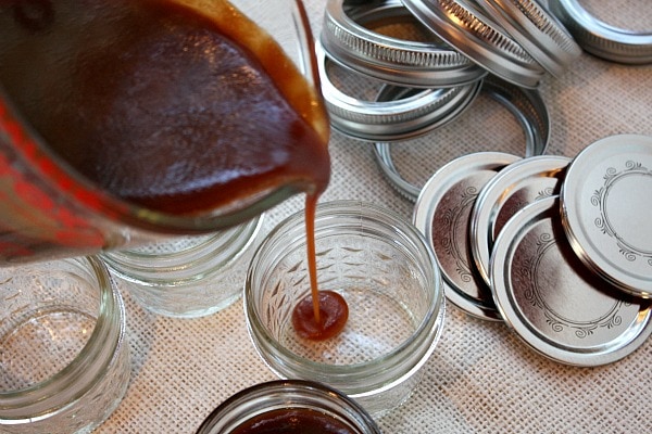 pouring salted caramel sauce into jars