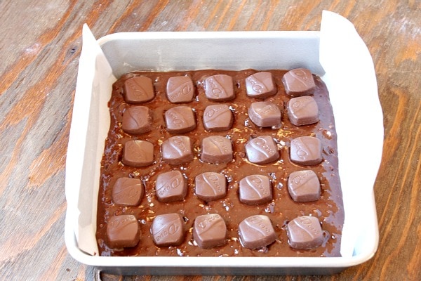brownie batter in pan with caramels on top