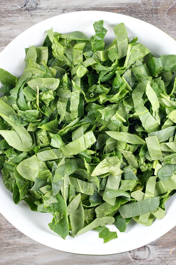 Spinach Salad with Chicken, Avocado and Goat Cheese recipe from RecipeGirl.com #spinach #salad #chicken #avocado #goat #cheese #goatcheese #recipe #RecipeGirl How to Make Spinach Salad with Chicken, Avocado and Goat Cheese with spinach in bowl
