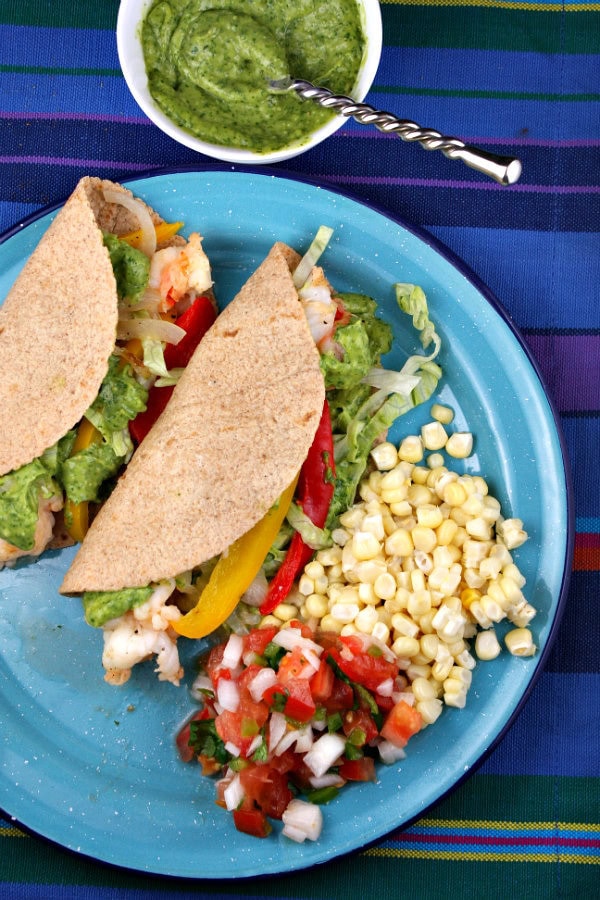 Shrimp Tacos with Avocado Chimichurri Sauce on a blue plate